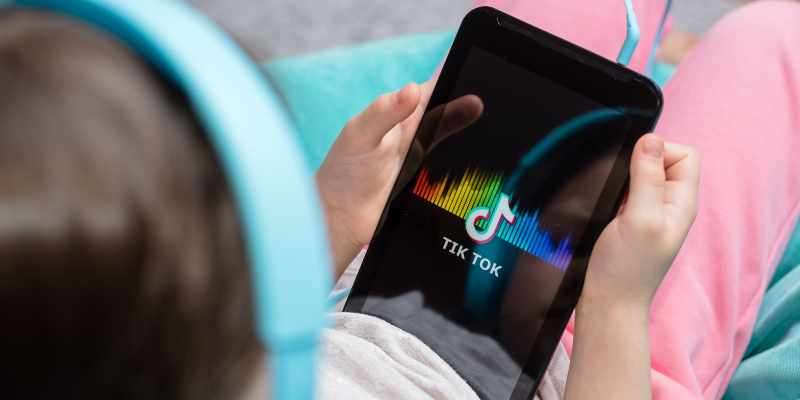 young Girl using tiktok on headphones 